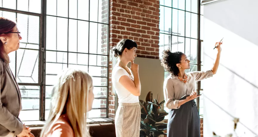 A group of colleagues brainstorming at a white board