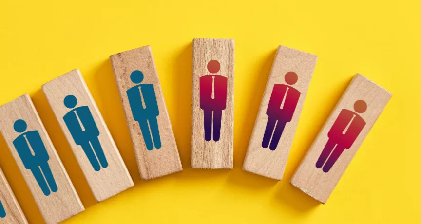 Shows wood blocks with peoples figures on them. The blocks are in a line, inclining. The last three are red and down turned.