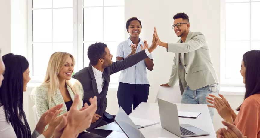 Two employees high fiving over a table