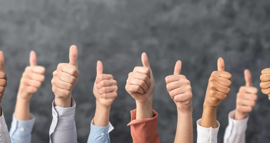 Image shows a bunch of people giving a thumbs up