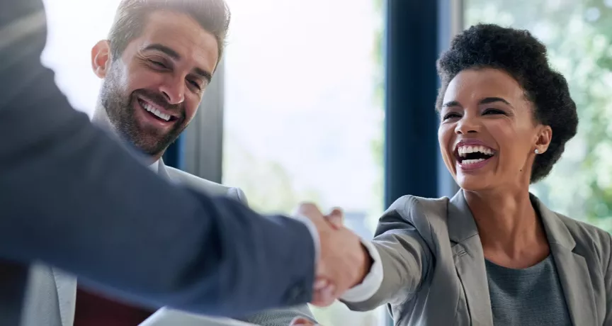 Image shows two employees shaking hands