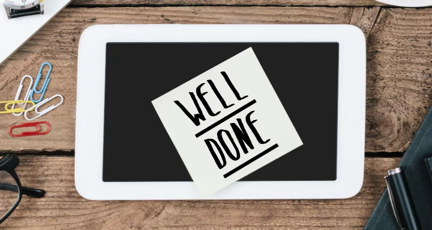 Image shows a sticky note on a desk that says "Well Done"