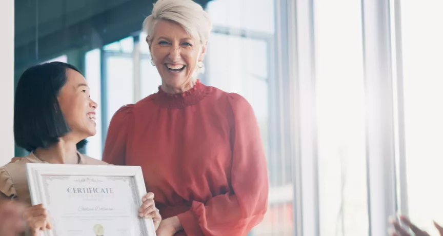 Image shows a leader presenting an employee award to a team member.