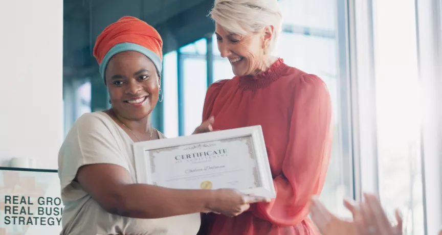 Shows a leader presenting an award to an employee