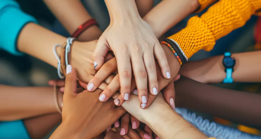 Shows a bunch of hands stacked together