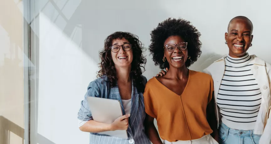three employees smiling at the camera
