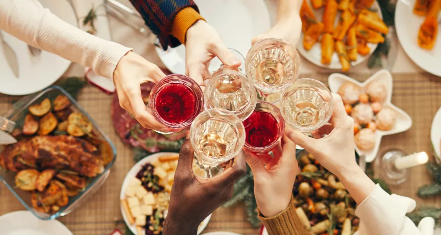 Employees celebrating at their office holiday party with drinks and food
