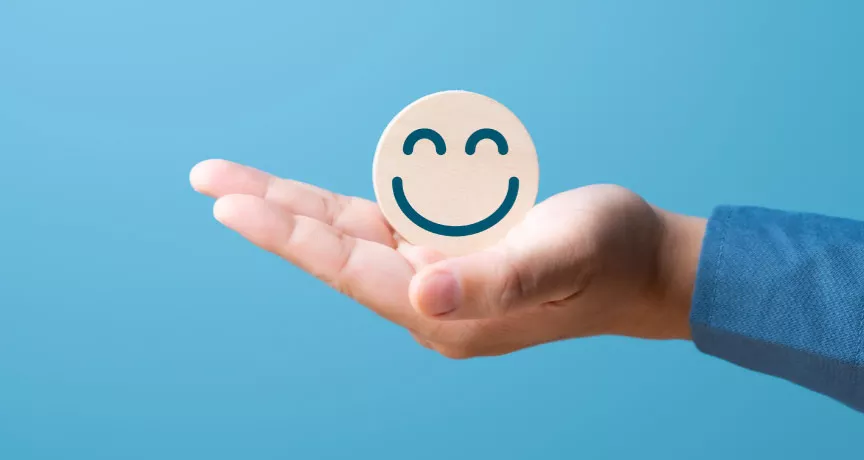 A hand holding a smiling face