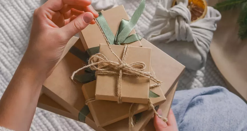 A HR professional manually wrapping a reward for their employee recognition program.