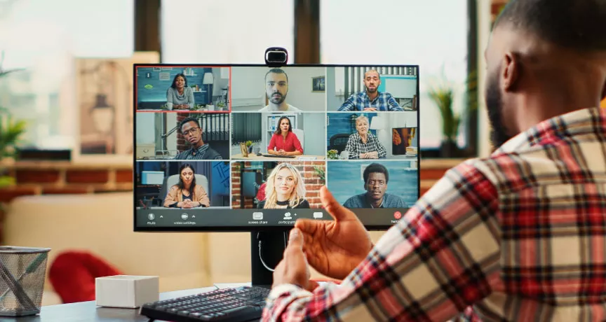 A remote new hire on their computer talking to their team virtually during onboarding