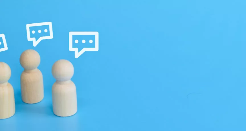 Three wood figurines giving feedback with text boxes over their head