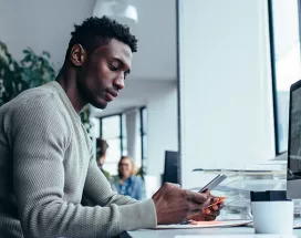 guy at desk using cell phone