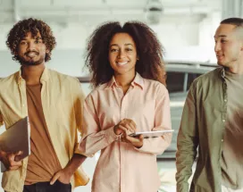 Five employees walking in an office looking happy