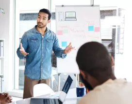 An employee presenting in front of three coworkers