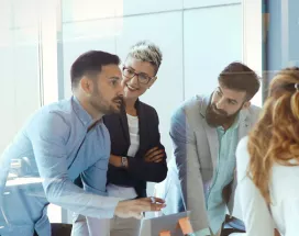 An image showing a team of six people gathered around a table