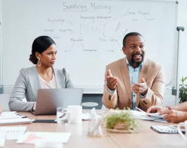 Coworkers sitting around a table with the focus on a one employee in the middle