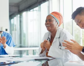 A small group of healthcare workers laughing and smiling at a table