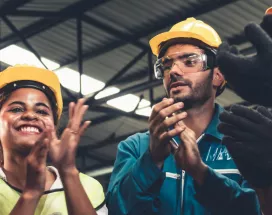 A photograph of construction workers clapping in a circle