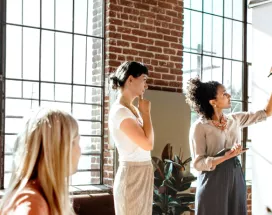 A group of colleagues brainstorming at a white board