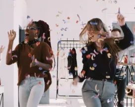 A team celebrating at work with confetti falling down in the background