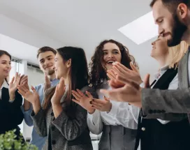 A group of employees cheering around a table