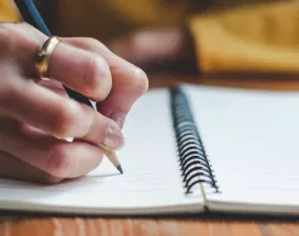 Image shows a close up of a person writing a message