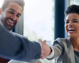 Image shows two employees shaking hands