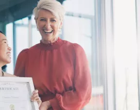 Image shows a leader presenting an employee award to a team member.