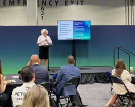 Image shows Theresa Harkins-Schulz, Inspirus SVP of Product and Customer Experience, speaking at the Total Rewards conference in front of attendees.