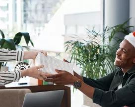 An employee giving their co-worker a holiday gift for appreciation