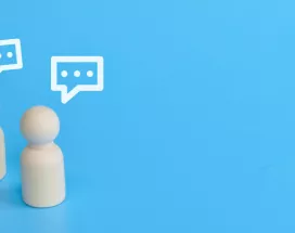 Three wood figurines giving feedback with text boxes over their head