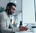 guy at desk using cell phone