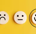 Four circles that display sad to happy faces with the happies smiley face circled