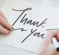 Person writing a thank you note
