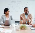 Coworkers sitting around a table with the focus on a one employee in the middle