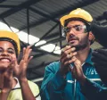 A photograph of construction workers clapping in a circle