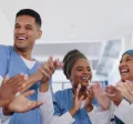 Three nurses and doctors celebrating by clapping their hands