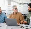 Team of engaged employees collaborating in a modern office, showing how culture helps retain talent