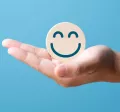 A hand holding a smiling face
