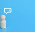 Three wood figurines giving feedback with text boxes over their head