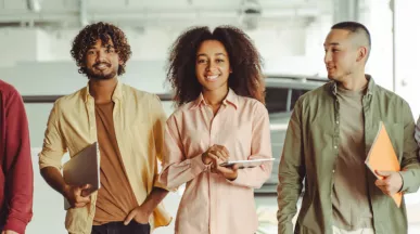 Five employees walking in an office looking happy