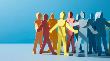 Paper stick figures huddled in a group