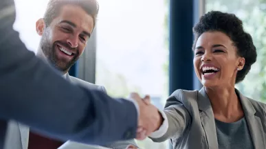 Image shows two employees shaking hands