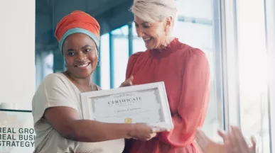 Shows a leader presenting an award to an employee