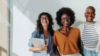 three employees smiling at the camera