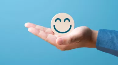 A hand holding a smiling face