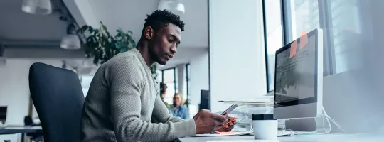 guy at desk using cell phone