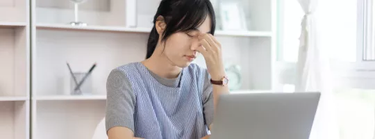 An employee that looks stressed at the computer