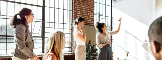 A group of colleagues brainstorming at a white board