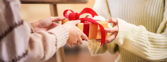 A person handing a gift to another person